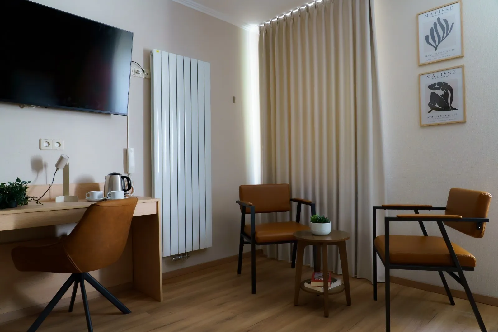 Quadruple Room: desk area, television and armchairs