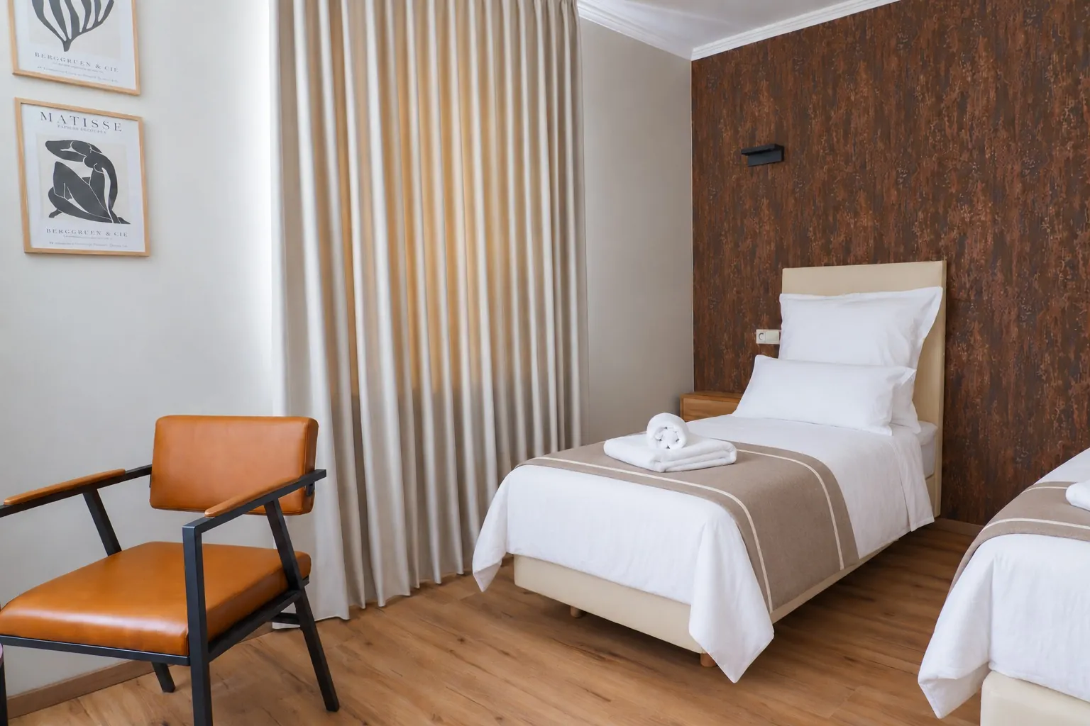 Quadruple Room: single bed, leather armchair and beige curtains