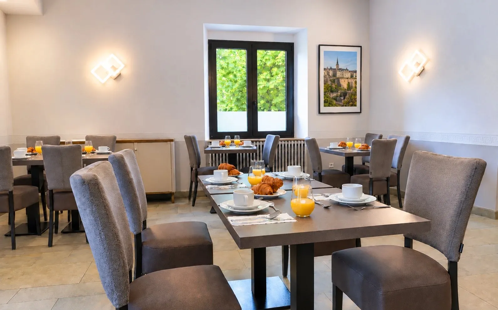 Breakfast room with set tables and a window onto the greenery